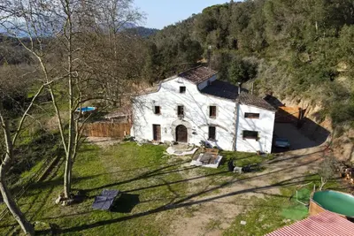 a large white house on a hill with trees at Casa Rural Can Ricós - El Mirador del Montseny in Vallgorguina