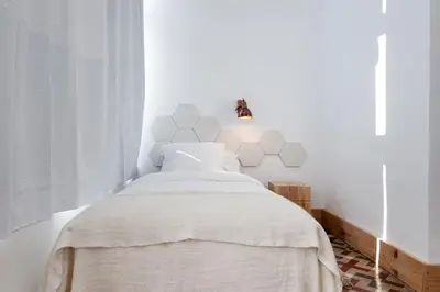 a bedroom with a bed with white walls at La Casa de Antonio Boutique Rooms in Barcelona