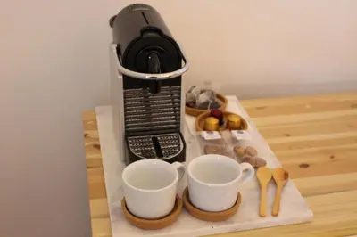 a black phone on a table with cups and spoons at La Casa de Antonio Boutique Rooms in Barcelona