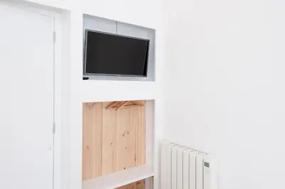 a living room with a tv and a radiator at La Casa de Antonio Boutique Rooms in Barcelona