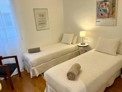 a room with two beds and a chair and a lamp at Apartamento con 2 Dormitorios, Elegante y Céntrico en Rambla Catalunya - ES-341-2 in Barcelona