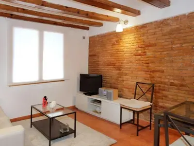 a living room with a brick wall and a tv at Apartamento Céntrico en Edificio Histórico con Encanto para Familias, Hasta 5 Personas - ES-341-1 in Barcelona