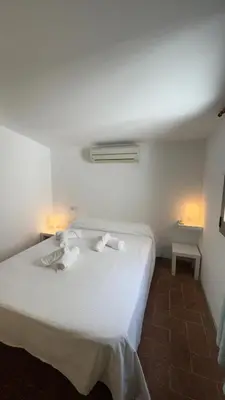 a white bed in a room with two lamps at SE Céntrico con Terraza in Terrassa