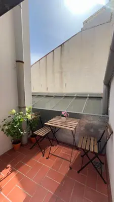 a patio with two chairs and a table on a building at SE Céntrico con Terraza in Terrassa