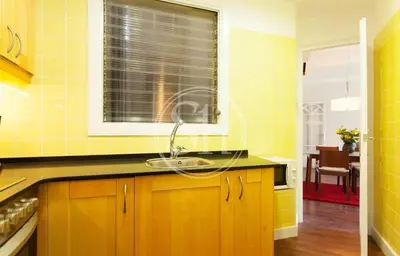 a yellow kitchen with a sink and a window at Bonito apartamento 3 in Barcelona