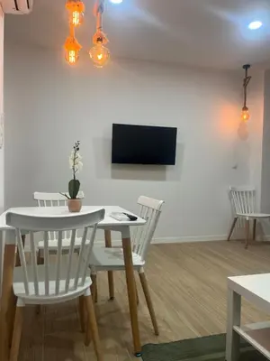 a dining room with a white table and chairs at Martiapartamento in Hospitalet de Llobregat