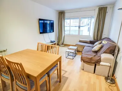 a living room with a table and a couch at Bambino apartment by Hello Homes Sitges in Sitges