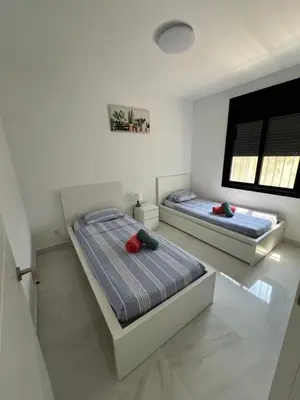 two beds in a white room with a window at Maison de Rêve avec Piscine Privative et Vue sur Mer - Proche Barcelone et Port Aventura in Cunit