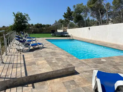 a swimming pool with blue chairs and a table at Maison de Rêve avec Piscine Privative et Vue sur Mer - Proche Barcelone et Port Aventura in Cunit