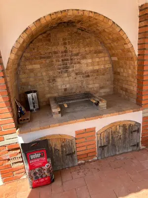 a brick oven with wooden doors on top of it at Maison de Rêve avec Piscine Privative et Vue sur Mer - Proche Barcelone et Port Aventura in Cunit
