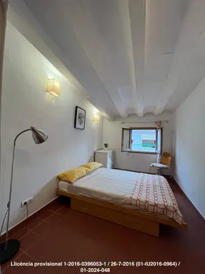 a bedroom with a bed and a lamp and a window at Encanto Gótico Histórico Cerca de Las Ramblas in Barcelona