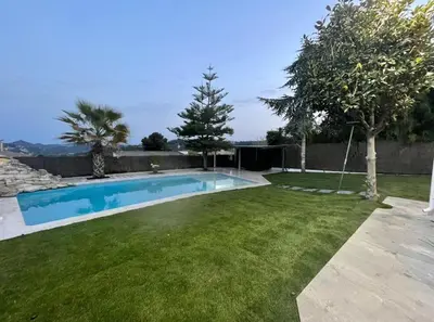 a backyard with a swimming pool and a grass yard at CASA CON JARDIN, SAUNA, PISCINA PRIVADA y NATURALEZA CERCA DE BARCELONA in Pallejá