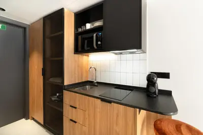 a kitchen with a sink and a black counter top at Residencia & Coliving para Postgrads in Barcelona