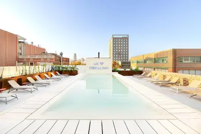 an outdoor patio with chairs and a sign on a building at Residencia & Coliving para Postgrads in Barcelona