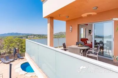 a couch and chairs sitting in front of a tree at Amazing views Villa Alizee with private pool sea views and Air Conditioning in Olivella