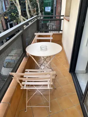 a small table and chairs on a balcony at Casa tonet in Badalona