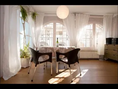 a dining room with a table and chairs and windows at Holiday home Anexa in Masnou