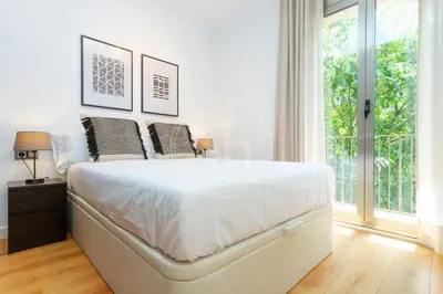a bedroom with a large white bed with two pillows at Cómodo apartamento en el Eixample in Barcelona