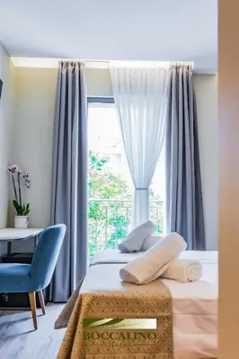 a bedroom with a bed and a window at Hotel Boccalino Sitges in Sitges