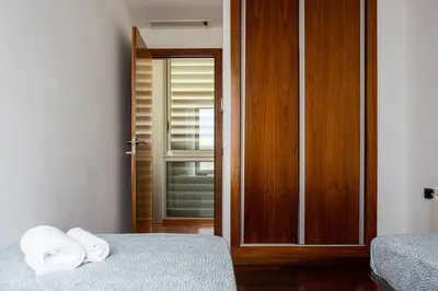a room with two beds and a sliding glass door at Dialez Holidays - Villarenys in Arenys de Mar