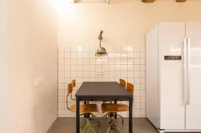 a black table with four chairs and a refrigerator at GuestReady - Unique Retreat in Barcelona in Barcelona