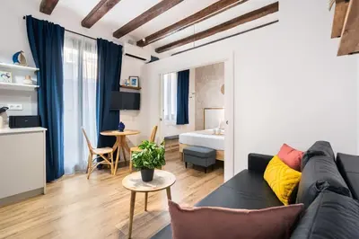 a living room with a couch and a bedroom at Lodging Apartments Almirall Beach 32 in Barcelona