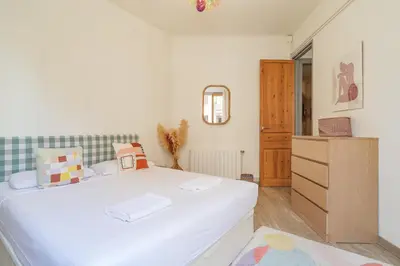 a bedroom with a white bed and a wooden cabinet at GuestReady - Bright apartment with balcony in Barcelona