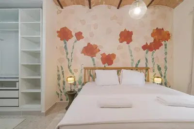 a bedroom with a bed with red flowers on the wall at GuestReady - Una estancia encantadora en Sarrià-Sant Gervasi in Barcelona