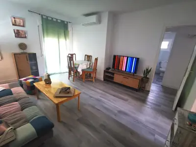 a living room with a couch and a table and a tv at Apartment close to the beach and the town centre in Castelldefels