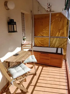a balcony with a bed and a table and chairs at Apartment close to the beach and the town centre in Castelldefels