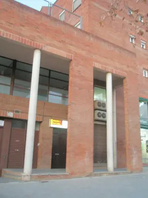 a brick building with two white columns at Tessasapartments Sabadell 2 in Sabadell