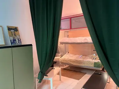 a room with two bunk beds with green curtains at Tessasapartments Sabadell 2 in Sabadell