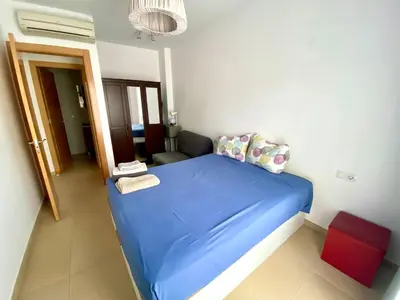 a small bedroom with a blue bed and a couch at Tranquilo y con terraza in Terrassa