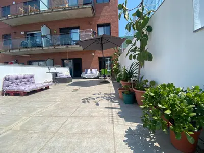 a patio with a purple couch and plants and an umbrella at Tranquilo y con terraza in Terrassa