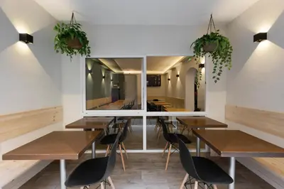 a dining room with wooden tables and chairs and a large mirror at Hostal Oliveta Budget in Barcelona