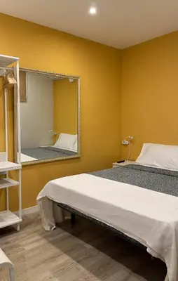 a bedroom with two beds and a mirror at Hostal Oliveta Budget in Barcelona