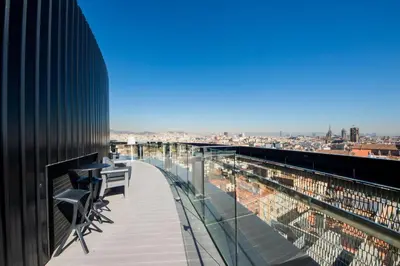 a balcony with chairs and a view of a city at Barceló Raval in Barcelona