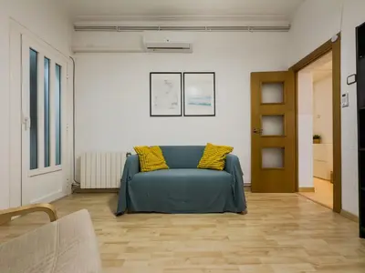 a living room with a blue couch and yellow pillows at GuestReady - Comfortable Retreat next to the beach in Barcelona
