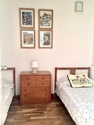 a bedroom with two beds and a dresser and pictures on the wall at Apartment Aptucat in Barcelona