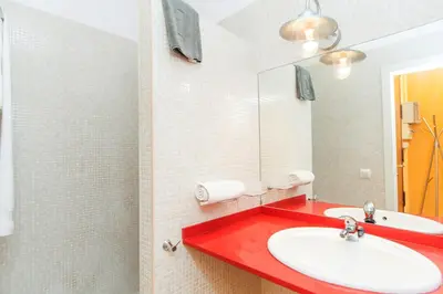 a bathroom with a red sink and a mirror at Apartment Aptucat in Barcelona