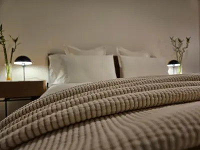 a bed with a brown blanket on top of it at EstudioSueñosSuite in Sant Just Desvern