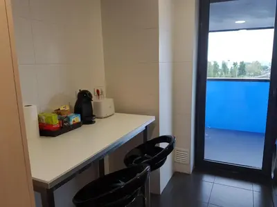 a room with two chairs and a counter with a table at Apartment Airport Barcelona Premium in Viladecáns
