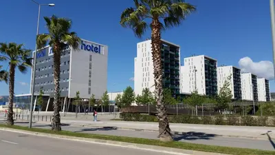 a street with palm trees in front of buildings at Apartment Airport Barcelona Premium in Viladecáns
