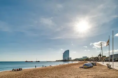 a beach with a building in the background at GuestReady - Precioso refugio en la Barceloneta in Barcelona