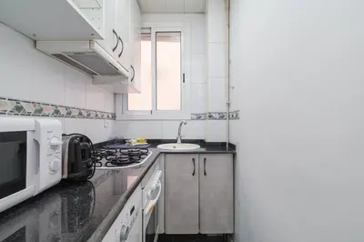 a kitchen with a stove and a microwave at GuestReady - Precioso refugio en la Barceloneta in Barcelona