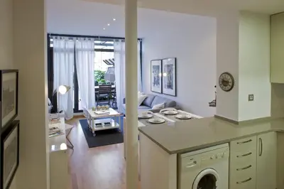 a kitchen and living room with a couch and a table at Flateli Llúria in Barcelona