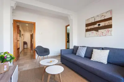 a living room with a blue couch and a table at Flateli Lepant in Barcelona