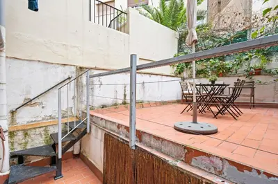 a balcony with stairs and a table and chairs at Flateli Fabra in Barcelona