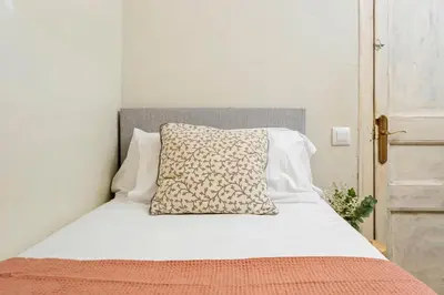 a white bed with a pillow on top of it at Flateli Fabra in Barcelona