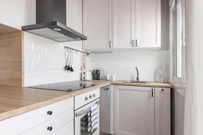 a kitchen with white cabinets and a sink at Flateli Roger 16 in Barcelona